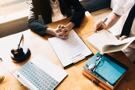 people-sitting-with-laptop-reviewing-paperwork