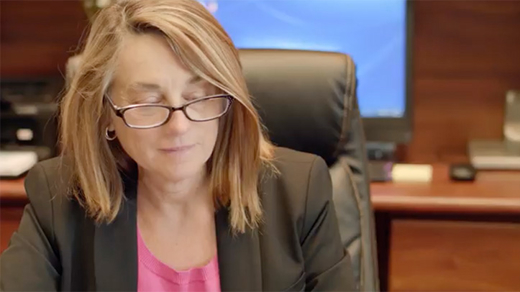 Anne E. Raduns looking down at desk